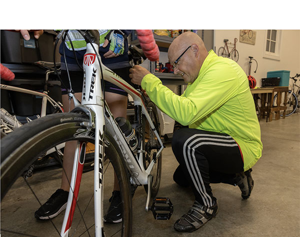 Greg Crawford adjusts pedals on a bicycle in his garage