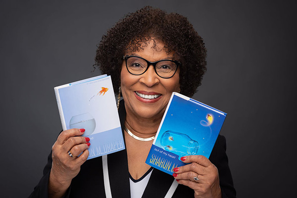 Sharon M. Draper holds her 'Out of My Mind' and 'Out of My Heart' middle-grade novels. "Out of My Mind" has been turned into a movie that will appear on Disney+ later this year.