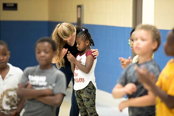 A Miami student teacher assists a young grade school student