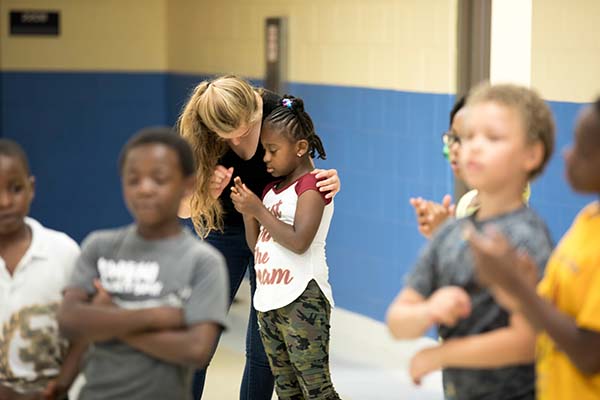 A Miami student teacher assists a young grade school student 