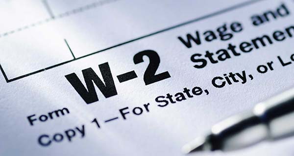 w-2 wage and tax form words and close up of a ballpoint pen