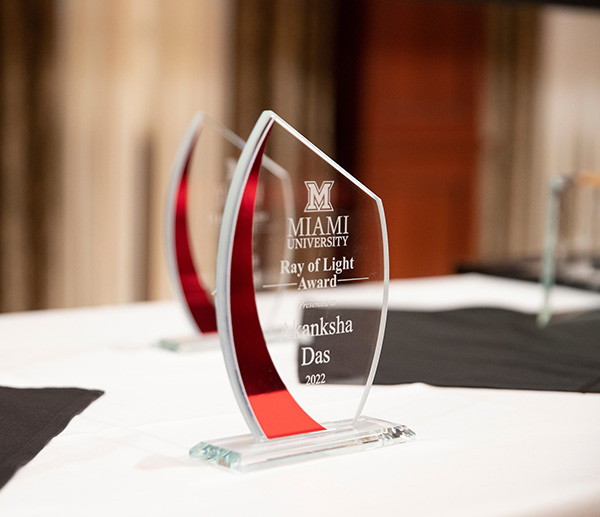 DEI Ray of Light Award on a table, with the name Akanksha Das 