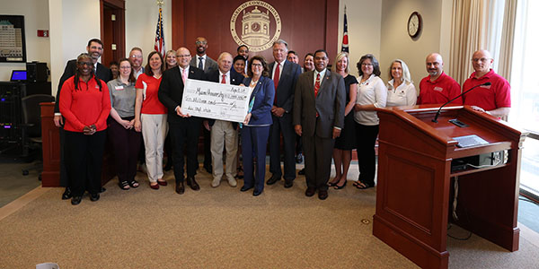 Members of Miami University and the Butler County Board of Commissioners pose with a symbolic check