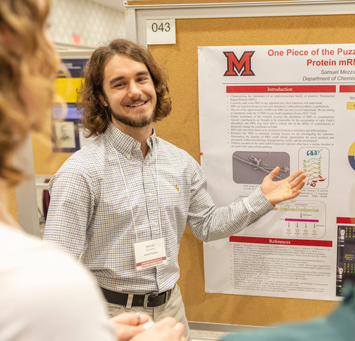 Samuel Mezzapelle shows his research poster at the forum