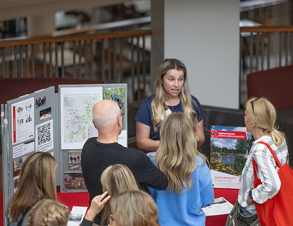 Alex Miller talks to parents and students at the resource fair in armstrong student center during orientation